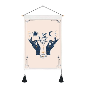 Bohemian tarot tapestry featuring sun, moon and hands with black tassels on dark blue canvas