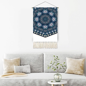 Bohemian blue mandala tapestry with white tassels hanging above a cozy living room sofa