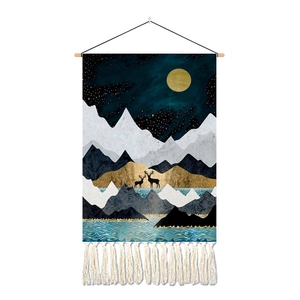 Detail of artistic mountain landscape tapestry with tassels and natural wood hanging rod