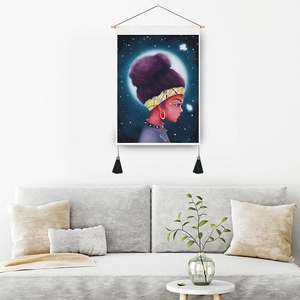 Artistic girl and moon tapestry with wooden rod and black tassels on a white wall