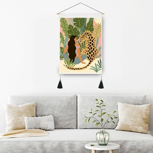 Artistic wall hanging tapestry featuring leopard and girl in tropical foliage with tassels