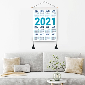 2021 minimalist fabric wall calendar with wood rod and blue typography over a sofa