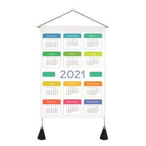 Detail of 2021 wall calendar fabric with wooden rod and decorative black tassels