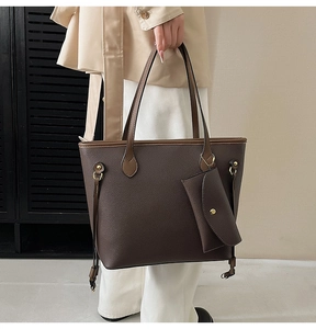 Détail du sac cabas en cuir grainé avec finitions dorées et petite pochette assortie