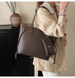Détail du cabas en cuir grainé marron foncé avec pochette sur le mannequin