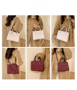 Détail du sac cabas carré crème et bordeaux avec bandoulière sur manteau en laine
