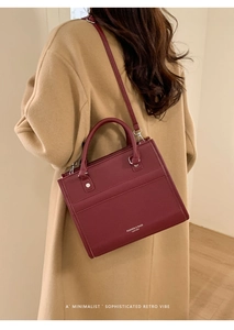 Détail du sac bandoulière en cuir bordeaux avec texte doré et bandoulière réglable