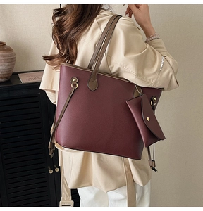 Détail du cabas bordeaux avec pochette assortie porté par un mannequin féminin