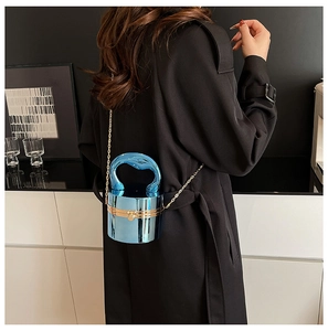 Detail of blue metallic cylinder evening bag featuring a thick curved top handle and gold chain