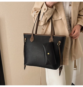 Détail du sac fourre-tout noir avec lanières brunes et une pochette amovible