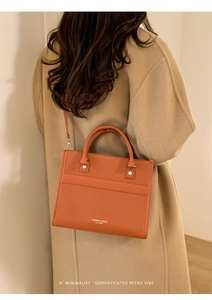 Sac bandoulière en cuir marron porté sur manteau en laine kaki pour style élégant