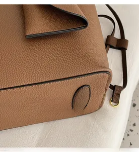 Détails de la base du sac cabas en cuir marron avec patins et boucles dorées