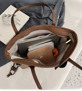 Intérieur spacieux d'un sac cabas en cuir marron avec rangement ordinateur et tablette