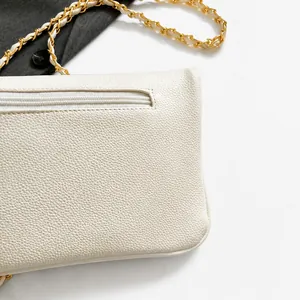 Vista detallada trasera de bolso de piel blanca con bolsillo de cremallera y cadena