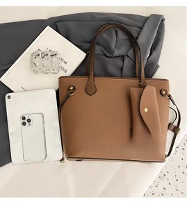 Détail du sac cabas en cuir marron montrant sa grande capacité pour tablette et mobile