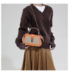 Detail of crossbody bag with silk scarf handle and chain strap on female model
