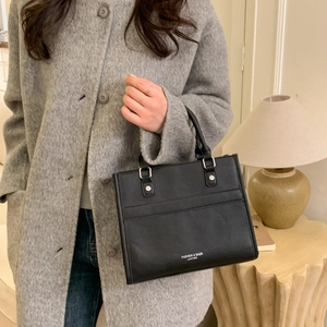 Sac fourre-tout carré en cuir noir avec surpiqûres décoratives et rivets argentés