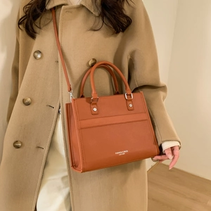Sac bandoulière carré chic en cuir grainé orange-brun avec des rivets métalliques
