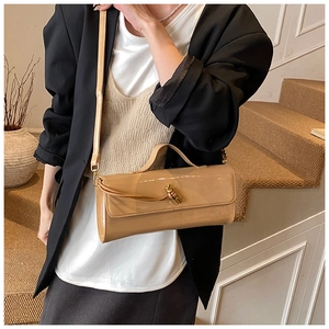Détail d'un sac baguette en cuir verni kaki clair avec un fermoir à boucle à nœud élégant