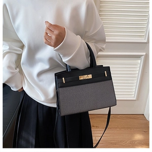 Detail of two-tone contrast tote bag featuring black leather and grey woven texture