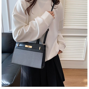 Detail of two-tone contrast tote bag with golden twist lock and adjustable shoulder strap