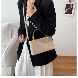 Close-up of beige woven texture bag with gold hardware and stylish braided shoulder strap