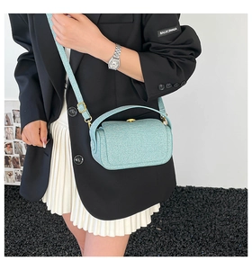 Détail du sac boîte bleu clair avec texture nacrée et finitions métalliques dorées