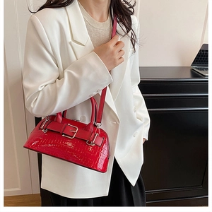 Detail of red crocodile texture shell bag with silver buckle and sleek handle