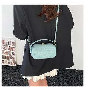Détail du sac bandoulière vert menthe avec texture scintillante et poignée supérieure