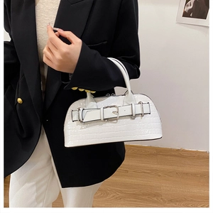 Detailed view of white crocodile pattern handbag with decorative buckle and firm handle