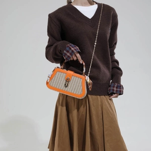 Orange woven straw crossbody bag with silk scarf handle and elegant metal chain strap