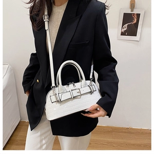 Close-up of a white crocodile texture shell handbag featuring a stylish belt buckle design