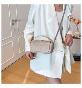 Détail du sac bandoulière pailleté or champagne avec bandoulière chaîne et boucle métal