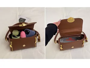 Detalle de bolso marrón con diseño litchi, cierre dorado y capacidad del bolsillo
