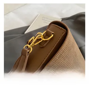 Detail of high-quality golden metal hook and textured woven fabric on vintage shoulder bag