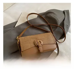 Detail showing mixed texture of woven fabric and leather on brown crossbody bag