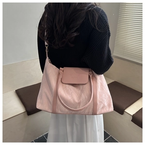Detail of pink fashion tote bag featuring pleated texture and adjustable strap