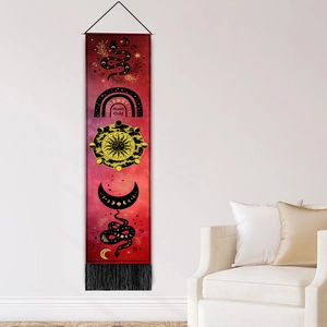 Vertical sun and moon tapestry with celestial symbols and black tassels on a white wall