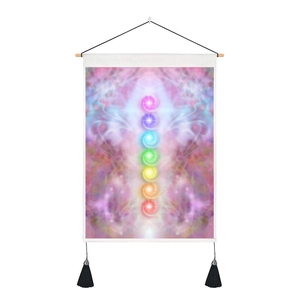 Detail view of colorful seven chakra wall tapestry with wooden scroll and black tassels