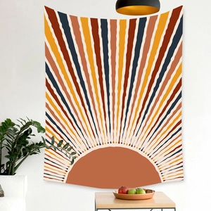 Detail of bohemian tapestry featuring sunburst design in warm earthy tones on white wall