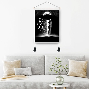 Modern wall tapestry with skull and birds illustration over a gray sofa in minimalist living room