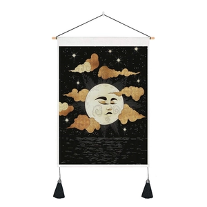 Detail of mystical sun and moon wall tapestry with tassels and wooden hanging rod
