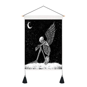 Detail of wall tapestry with skull and wings print, wooden rod, and black tassels