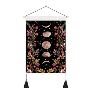 Detail of floral moon phase tapestry with wooden hanging rod and black velvet tassels