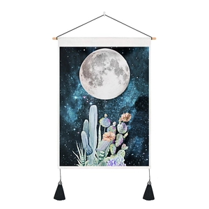 Detail of moon and cactus tapestry with wooden hanging rod and black tassels