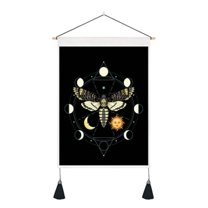 Detail of moth tapestry with moon phases, sun motifs, and black tassels on wooden hanger