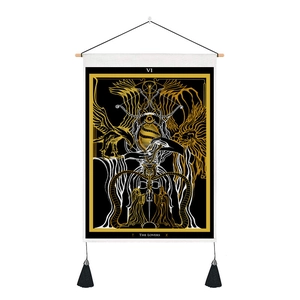 Détail de la tenture tarot THE LOVERS avec motif noir et or et finitions à pompons noirs