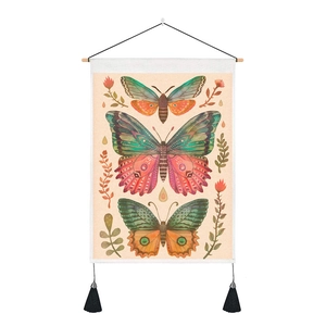 Detail of vintage butterfly tapestry with floral art, wooden rod, and black tassels