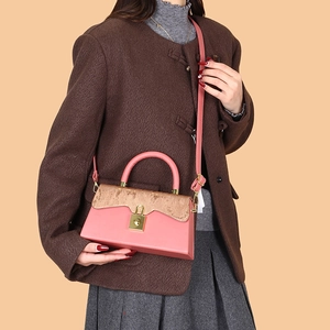 Borsa a mano rosa in pelle con patta dorata e fibbia elegante da donna su sfondo chiaro
