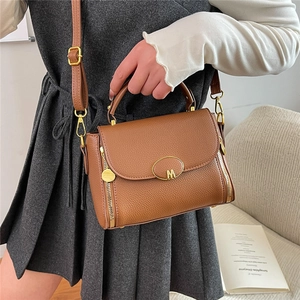 Vintage brown lychee grain leather handbag with gold M logo and adjustable shoulder strap